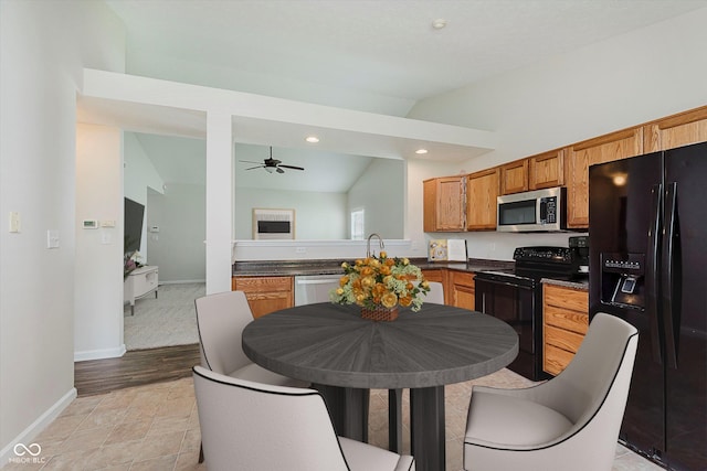 12121 Driftstone Dr, Fishers, IN 46037 - kitchen featuring black appliances, vaulted ceiling, a ceiling fan, dark countertops, and brown cabinetry