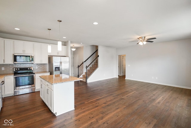 6670 Shooting Star Dr, Whitestown, IN 46075 - kitchen with stainless steel appliances, open floor plan, a center island, backsplash, and ceiling fan