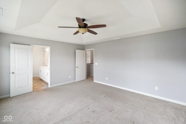 6670 Shooting Star Dr, Whitestown, IN 46075 - unfurnished bedroom with a tray ceiling, light carpet, ensuite bath, and a ceiling fan