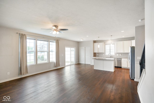 6670 Shooting Star Dr, Whitestown, IN 46075 - unfurnished living room featuring dark wood-style flooring, ceiling fan, a textured ceiling, and recessed lighting