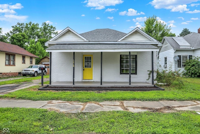 1418 W 5th St, Anderson, IN 46016 - view of front of home featuring covered porch, brick siding, a shingled roof, and a front yard