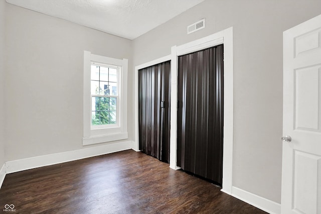 1418 W 5th St, Anderson, IN 46016 - unfurnished bedroom with dark wood finished floors and baseboards