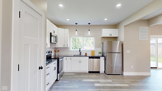 1809 S H St, Elwood, IN 46036 - kitchen featuring stainless steel appliances, dark countertops, light wood-style flooring, tasteful backsplash, and recessed lighting