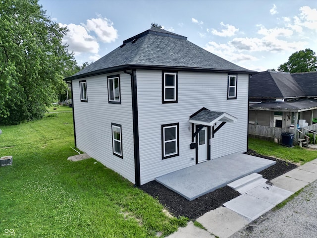 1809 S H St, Elwood, IN 46036 - view of front of house featuring roof with shingles, a front yard, and a patio