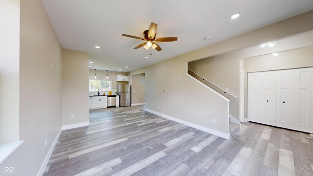 1809 S H St, Elwood, IN 46036 - unfurnished living room with a ceiling fan, stairway, light wood-style floors, and recessed lighting
