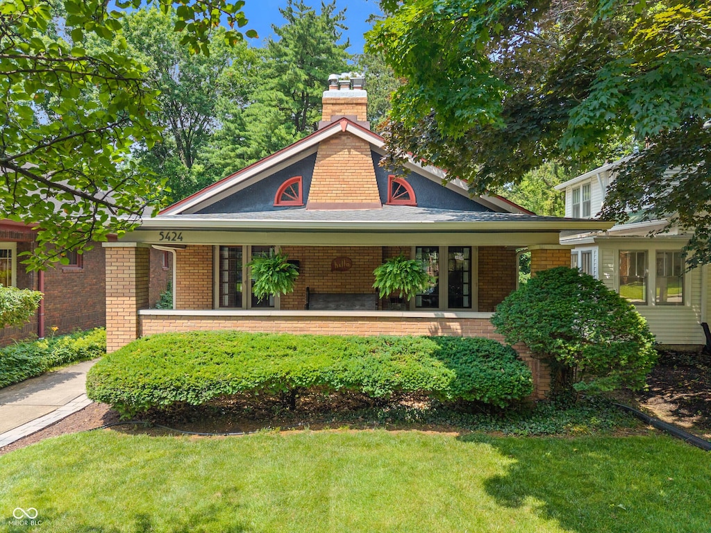 5424 Broadway St, Indianapolis, IN 46220 - view of front facade with brick siding, a front lawn, and a porch