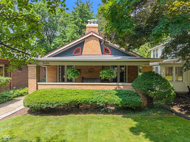 5424 Broadway St, Indianapolis, IN 46220 - view of front facade with brick siding, a front lawn, and a porch