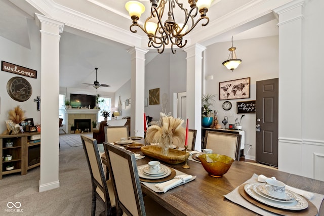 15098 Newburyport Dr, Fortville, IN 46040 - carpeted dining space featuring decorative columns, a ceiling fan, a tiled fireplace, high vaulted ceiling, and a chandelier