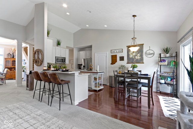 15098 Newburyport Dr, Fortville, IN 46040 - kitchen featuring stainless steel appliances, a kitchen bar, ornate columns, a peninsula, and white cabinets