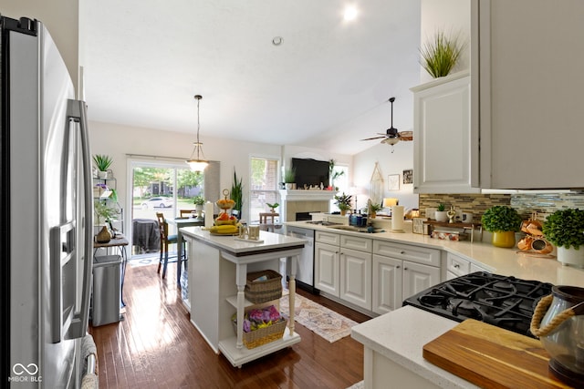 15098 Newburyport Dr, Fortville, IN 46040 - kitchen featuring appliances with stainless steel finishes, tasteful backsplash, ceiling fan, a tiled fireplace, and white cabinets