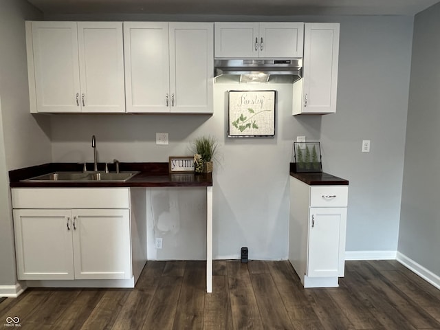 937 N Routiers Ave, Indianapolis, IN 46219 - kitchen with dark countertops, dark wood-style floors, white cabinetry, and under cabinet range hood