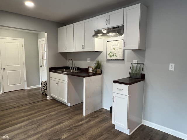 937 N Routiers Ave, Indianapolis, IN 46219 - kitchen featuring dark countertops, dark wood-type flooring, under cabinet range hood, white cabinetry, and recessed lighting