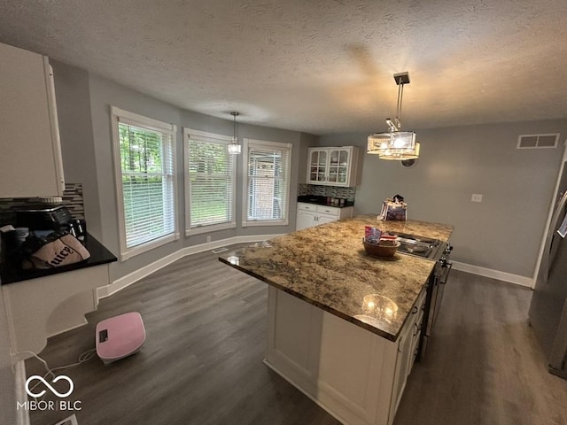 8407 Campbell Ct, Mooresville, IN 46158 - kitchen with white cabinetry, dark wood-style floors, a kitchen island, glass insert cabinets, and a textured ceiling