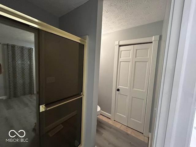 8407 Campbell Ct, Mooresville, IN 46158 - full bathroom with wood finished floors, a shower with shower door, and a textured ceiling