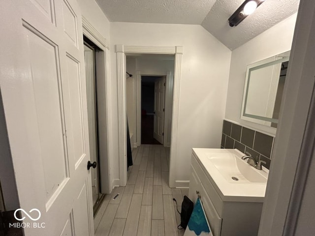 8407 Campbell Ct, Mooresville, IN 46158 - bathroom with a textured ceiling, vanity, wood finished floors, and lofted ceiling