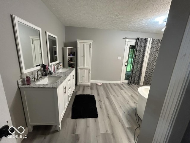 8407 Campbell Ct, Mooresville, IN 46158 - full bath with wood finished floors, double vanity, a textured ceiling, a freestanding bath, and curtained shower