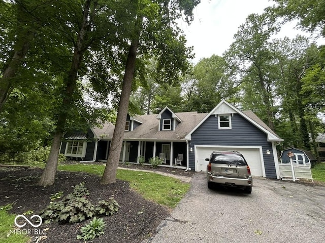 8407 Campbell Ct, Mooresville, IN 46158 - cape cod house featuring asphalt driveway, an attached garage, roof with shingles, and view of wooded area