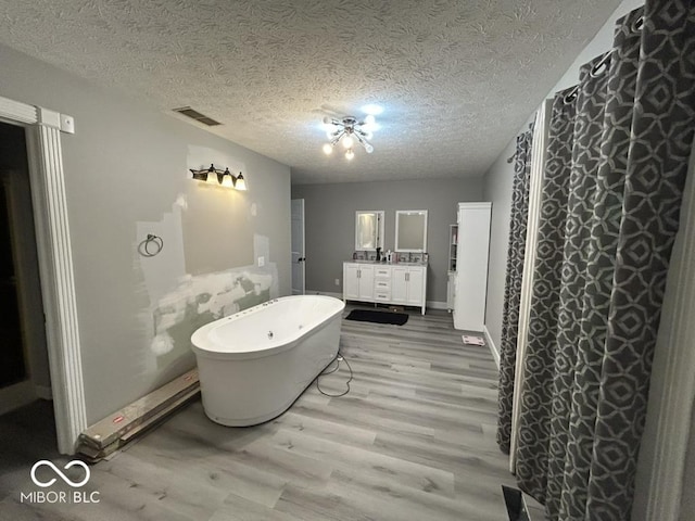 8407 Campbell Ct, Mooresville, IN 46158 - full bath with wood finished floors, vanity, a freestanding tub, and a textured ceiling