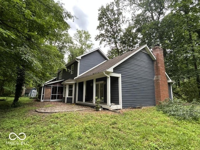 8407 Campbell Ct, Mooresville, IN 46158 - rear view of property featuring a sunroom, a lawn, a chimney, and a storage shed