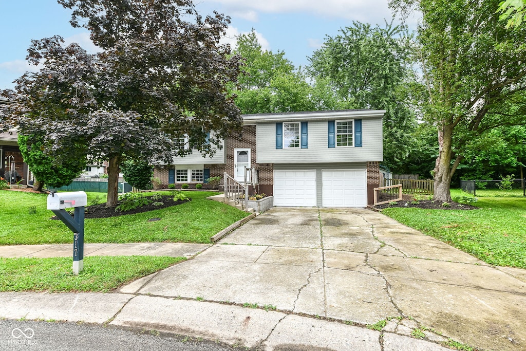 317 Heritage Ct, Fishers, IN 46038 - bi-level home with brick siding, a garage, and driveway