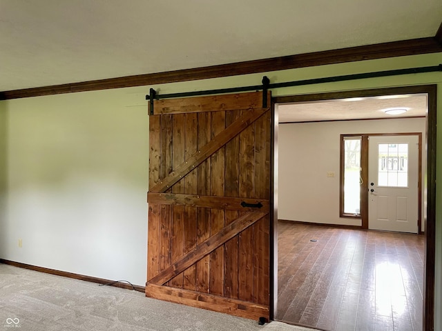 540 Lazy Ln, Greenwood, IN 46142 - foyer featuring a barn door, crown molding, and wood finished floors