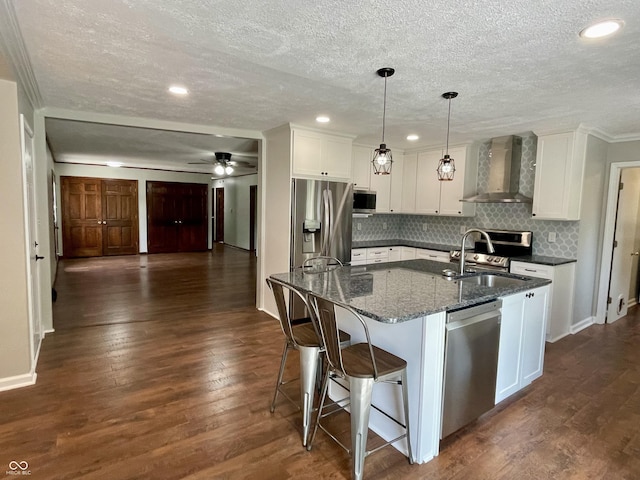 540 Lazy Ln, Greenwood, IN 46142 - kitchen featuring wall chimney range hood, appliances with stainless steel finishes, a textured ceiling, white cabinetry, and tasteful backsplash