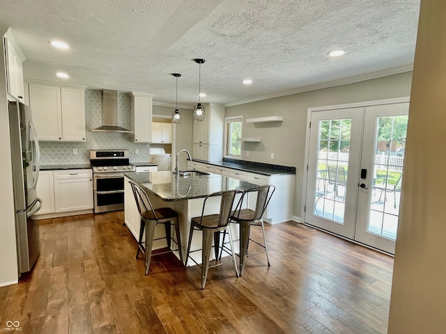 540 Lazy Ln, Greenwood, IN 46142 - kitchen with wall chimney exhaust hood, stainless steel appliances, crown molding, plenty of natural light, and french doors