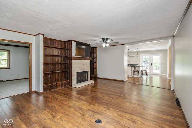 540 Lazy Ln, Greenwood, IN 46142 - unfurnished living room featuring ornamental molding, a ceiling fan, a fireplace, hardwood / wood-style floors, and a textured ceiling