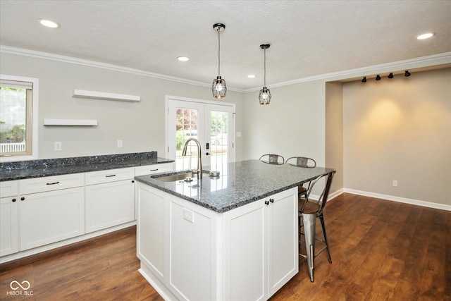 540 Lazy Ln, Greenwood, IN 46142 - kitchen featuring ornamental molding, dark wood-style flooring, white cabinetry, a kitchen bar, and dark stone counters