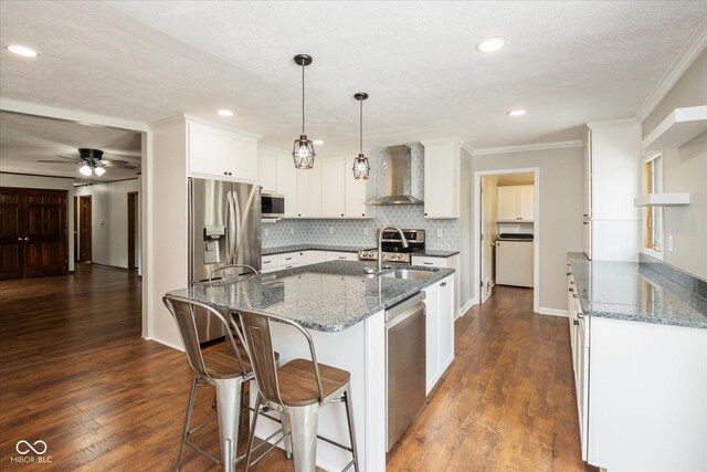 540 Lazy Ln, Greenwood, IN 46142 - kitchen featuring wall chimney range hood, appliances with stainless steel finishes, dark stone countertops, white cabinetry, and ornamental molding