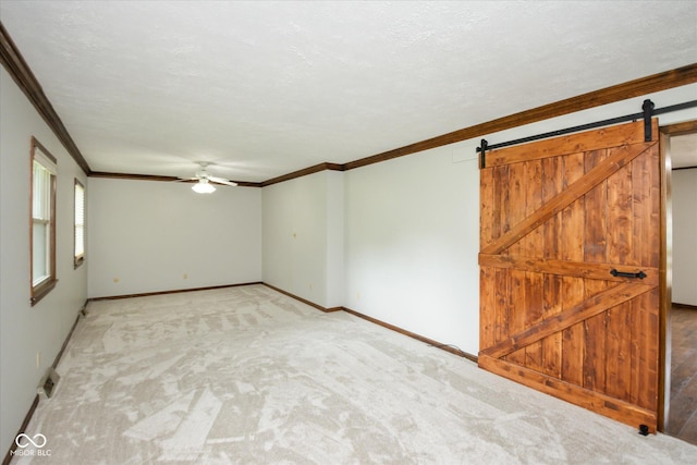 540 Lazy Ln, Greenwood, IN 46142 - unfurnished room with a ceiling fan, a barn door, ornamental molding, light colored carpet, and a textured ceiling