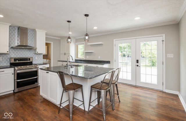 540 Lazy Ln, Greenwood, IN 46142 - kitchen featuring range with two ovens, wall chimney exhaust hood, french doors, white cabinets, and crown molding