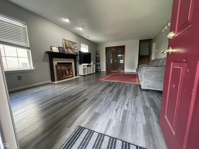 1503 Quinlan Ct, Indianapolis, IN 46217 - unfurnished living room with wood finished floors, a textured ceiling, a fireplace with flush hearth, and stairs