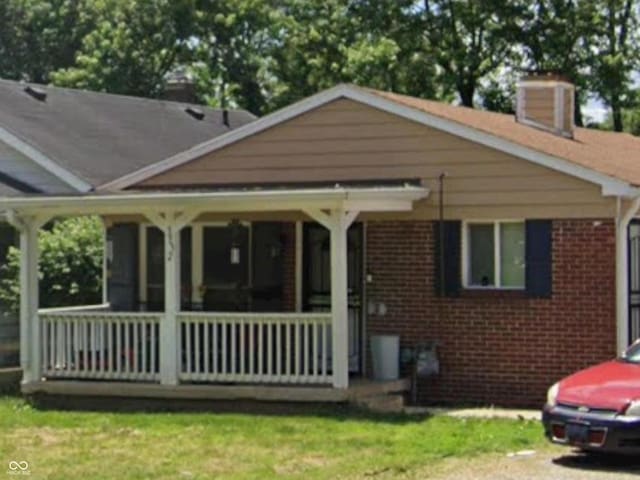 3932 Millersville Dr, Indianapolis, IN 46205 - view of front of property with brick siding, a chimney, and a front yard