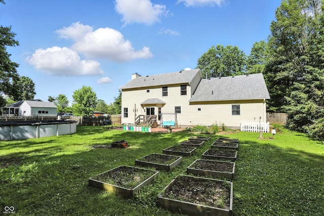 1224 S Hunter Rd, Indianapolis, IN 46239 - back of house featuring a garden, a covered pool, a chimney, and a fenced backyard