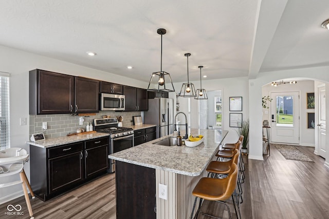 1414 W Springhurst Blvd, Greenfield, IN 46140 - kitchen with stainless steel appliances, dark wood finished floors, arched walkways, tasteful backsplash, and recessed lighting