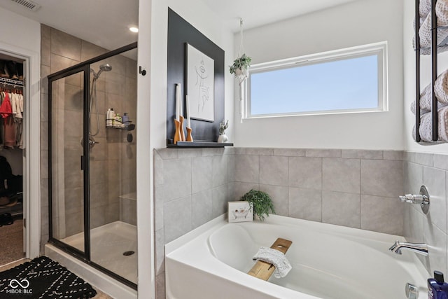 1414 W Springhurst Blvd, Greenfield, IN 46140 - bathroom featuring a bath, a stall shower, and a walk in closet