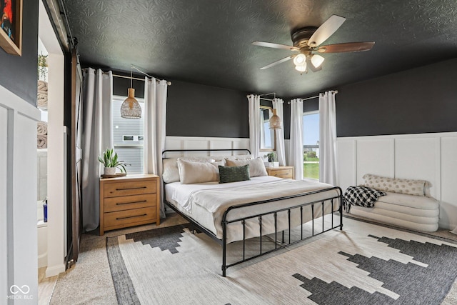 1414 W Springhurst Blvd, Greenfield, IN 46140 - bedroom featuring wainscoting, a textured ceiling, a decorative wall, and a ceiling fan