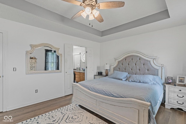 401 N Nicole Ln, Scottsburg, IN 47170 - bedroom with dark wood-style floors, connected bathroom, a raised ceiling, and a ceiling fan