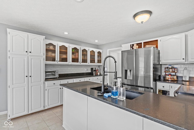 401 N Nicole Ln, Scottsburg, IN 47170 - kitchen featuring stainless steel refrigerator with ice dispenser, dark countertops, glass insert cabinets, backsplash, and white cabinets