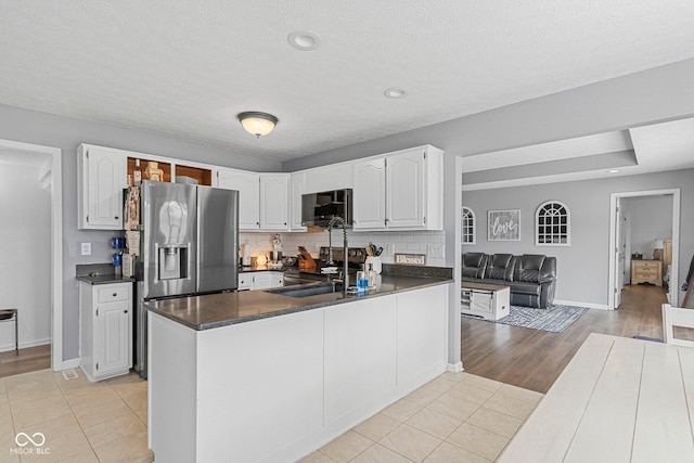 401 N Nicole Ln, Scottsburg, IN 47170 - kitchen with dark countertops, stainless steel fridge, white cabinetry, light tile patterned floors, and a textured ceiling