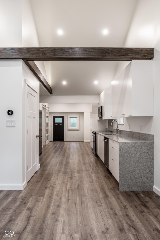 4245 Norwaldo Ave, Indianapolis, IN 46205 - kitchen with white cabinetry, appliances with stainless steel finishes, wood finished floors, beam ceiling, and open floor plan