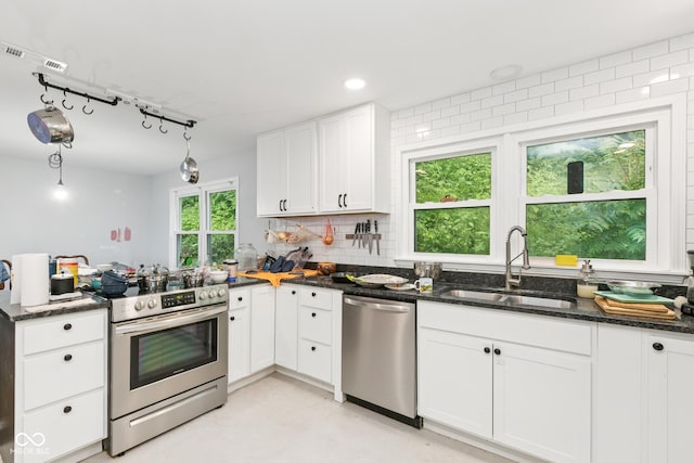 8783 State Road 56, Aurora, IN 47001 - kitchen with appliances with stainless steel finishes, white cabinets, dark stone counters, a peninsula, and decorative backsplash