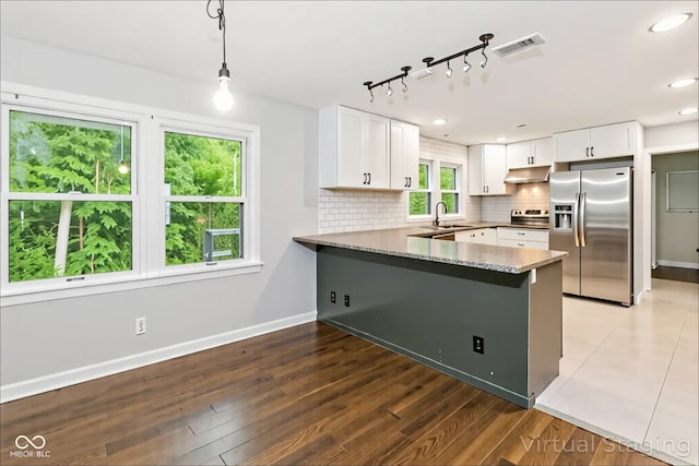 8783 State Road 56, Aurora, IN 47001 - kitchen featuring stainless steel refrigerator with ice dispenser, under cabinet range hood, a peninsula, backsplash, and white cabinetry