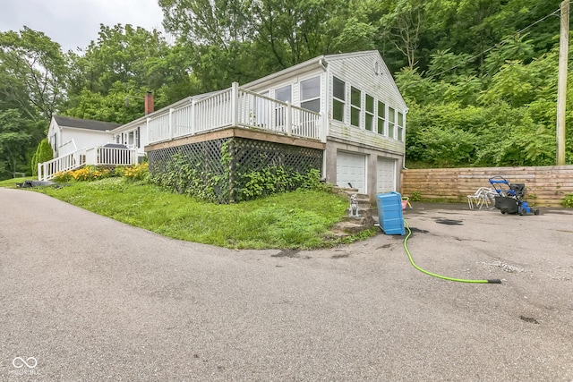 8783 State Road 56, Aurora, IN 47001 - view of front of home featuring a deck, a garage, view of scattered trees, and driveway