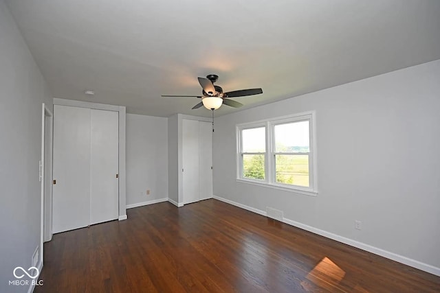 8783 State Road 56, Aurora, IN 47001 - unfurnished bedroom with multiple closets, dark wood-type flooring, and ceiling fan