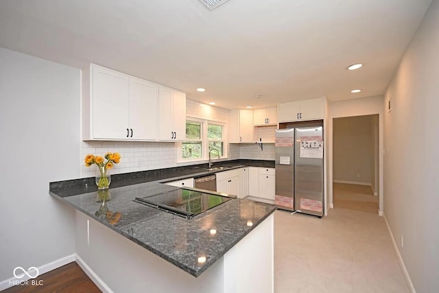8783 State Road 56, Aurora, IN 47001 - kitchen with appliances with stainless steel finishes, backsplash, dark stone countertops, a peninsula, and white cabinetry