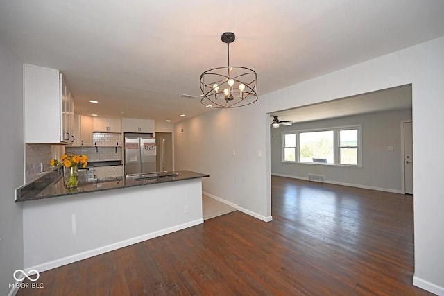 8783 State Road 56, Aurora, IN 47001 - kitchen with stainless steel fridge, a chandelier, dark wood finished floors, backsplash, and white cabinets