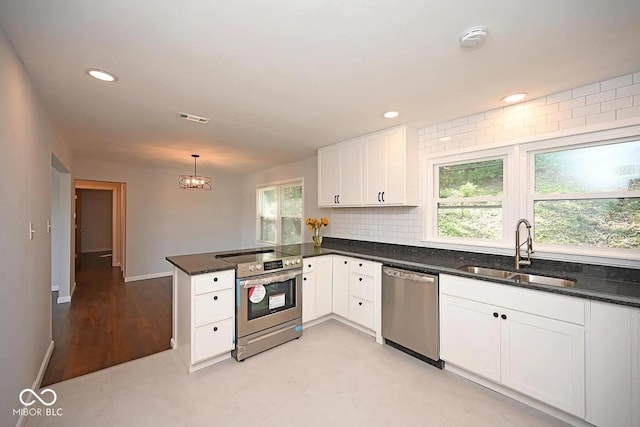 8783 State Road 56, Aurora, IN 47001 - kitchen featuring appliances with stainless steel finishes, a peninsula, white cabinetry, dark stone counters, and recessed lighting