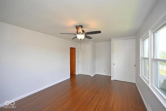 8783 State Road 56, Aurora, IN 47001 - unfurnished bedroom featuring multiple closets, dark wood finished floors, and ceiling fan